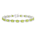 Sterling silver tennis bracelet with oval peridot stones and diamond accents, clasp