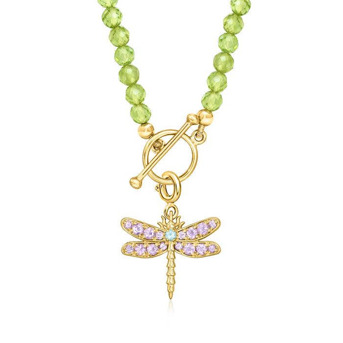 Gold dragonfly charm with purple wings and light blue center on green beaded necklace