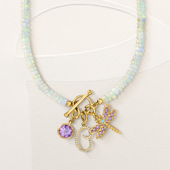 Gold dragonfly charm with purple stones and blue center on pale blue beaded necklace