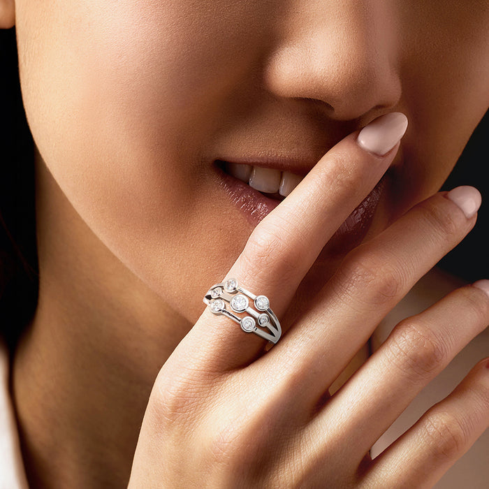 Sterling silver diamond ring with bezel-set round stones, worn on hand