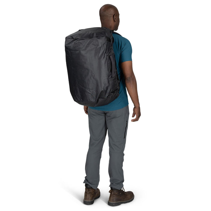On-Body Backpack Carry (Rear View) – Male model wearing the Osprey Transporter Duffel 65 in Raven Black as a backpack, rear angle.